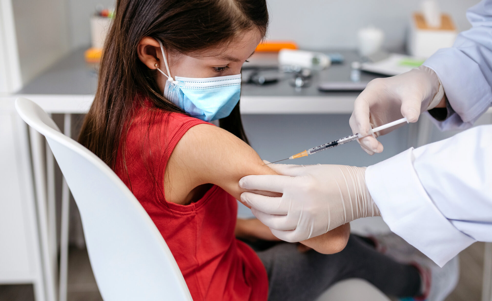 Girl receiving coronavirus vaccine at doctor's office